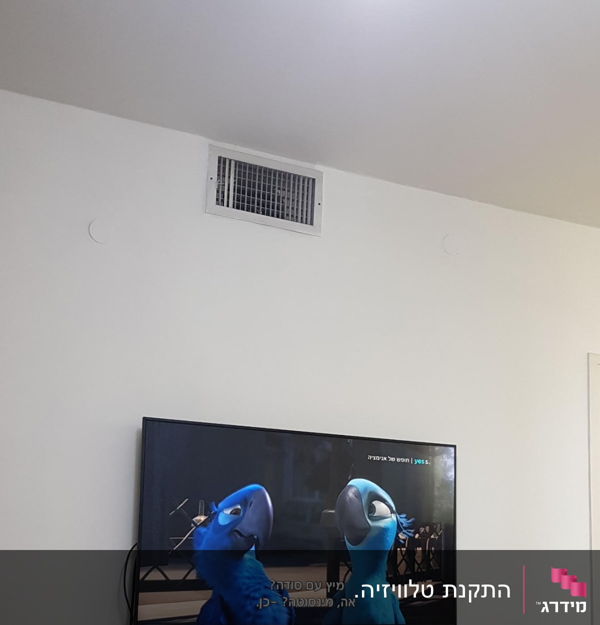 טלוויזיה תלויה על הקיר עם כבלים גלויים